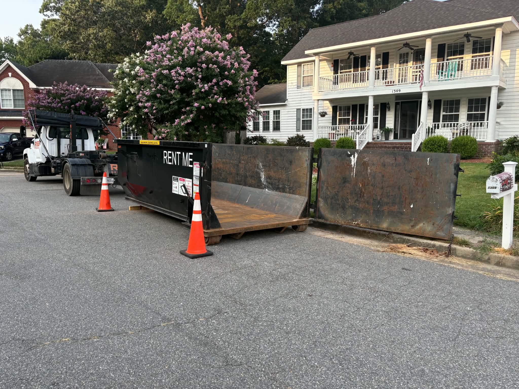 RISE Dumpsters 15-yard roll-off dumpster rental loaded with debris at a Chesapeake, VA job site.