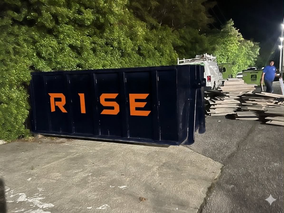 Front view of a RISE Dumpsters roll-off container placed on a residential driveway — no driveway damage guaranteed.